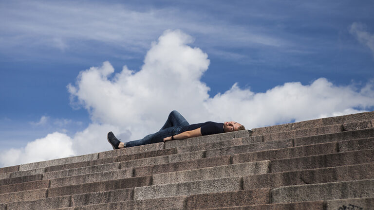 En man som donerat stamceller ligger högst upp på trapporna vid Helsingfors domkyrka.
