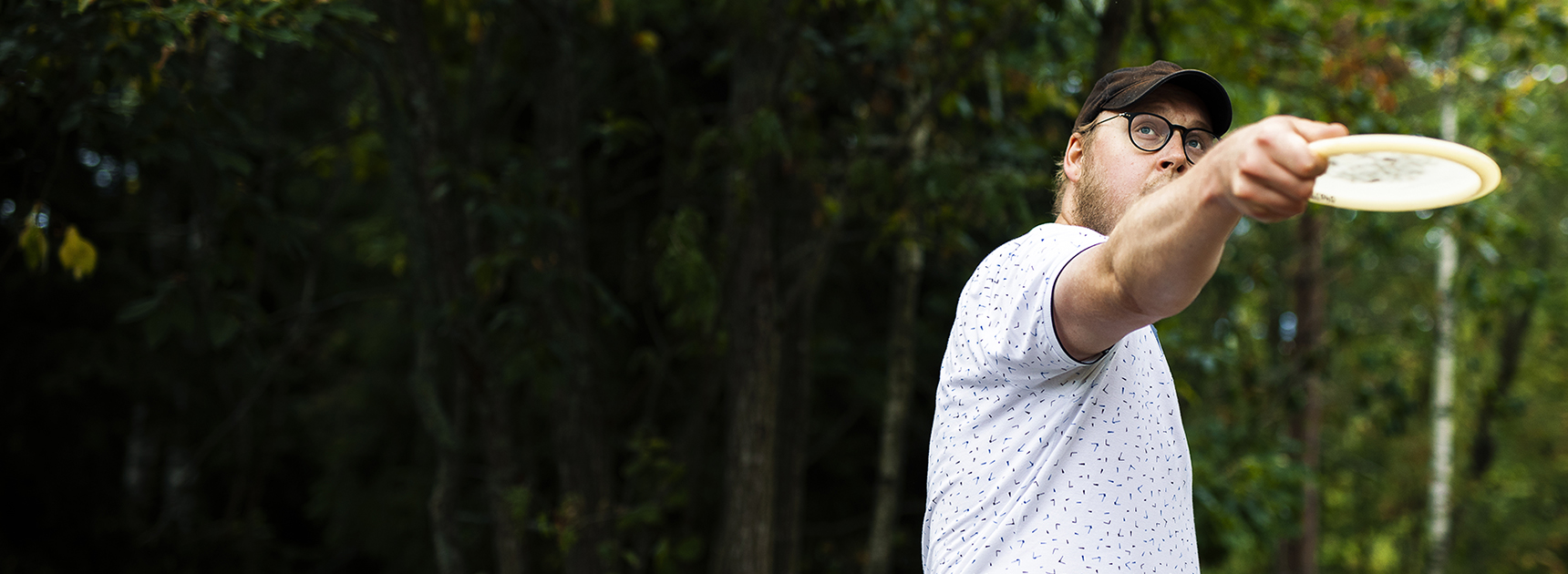 Mies heittää frisbeetä.