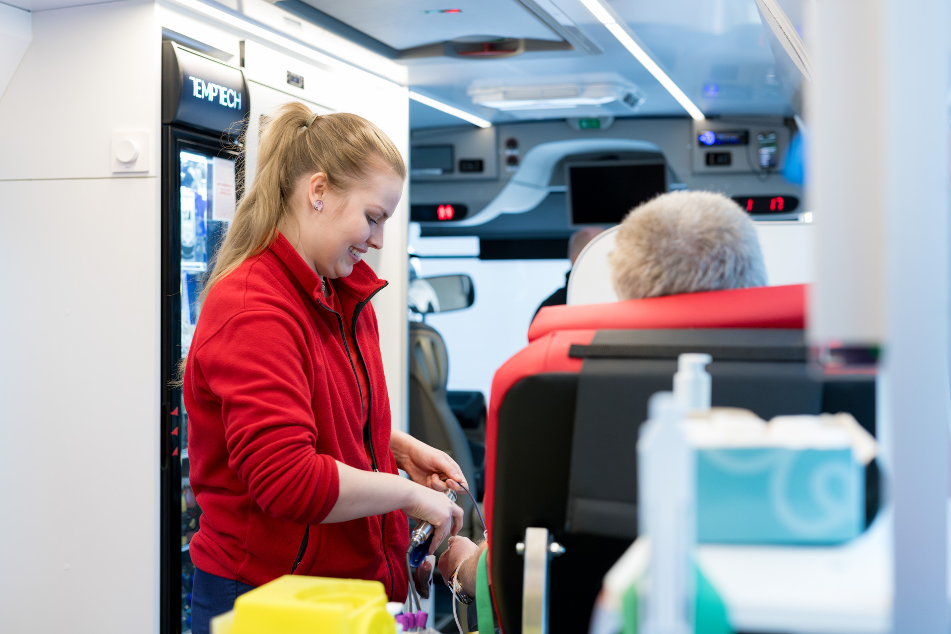Hoitaja valmistelemassa verenluovutusta Verenluovutusbussissa.