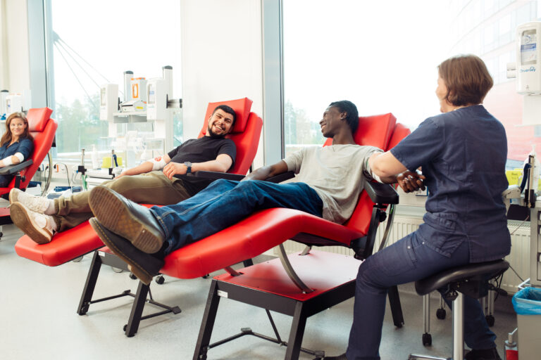 Two men and one woman donating blood at the Blood Service center in Vantaa.