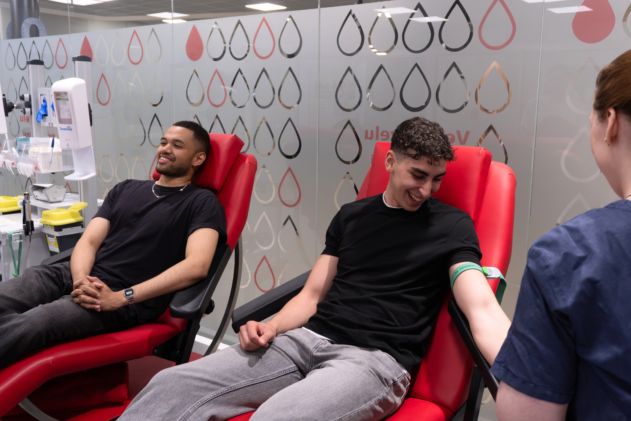 Kaksi nuorta miestä verenluovutuksessa Tampereen toimipisteessä.