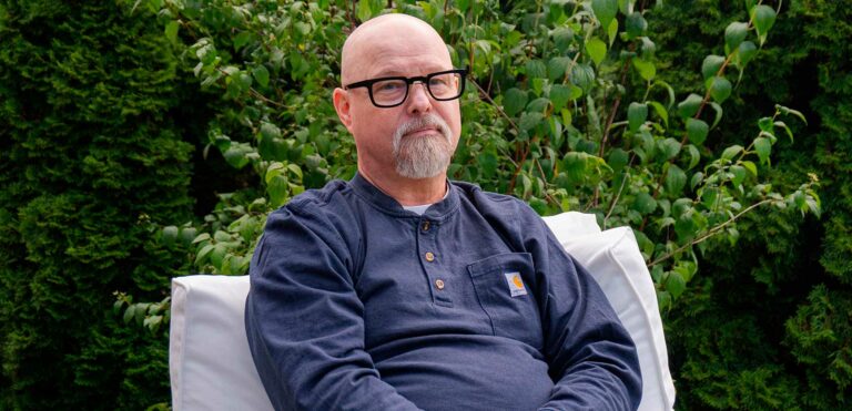 Kimmo Ståhlberg kuvattuna ulkona istumassa tuolilla.