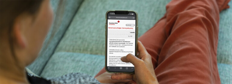 Verenluovuttaja katsoo terveyskyselyä puhelimen ruudulta.